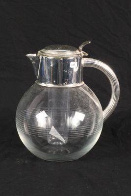 a glass pitcher with a bird on it on a black background