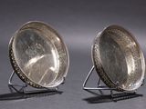 pair of antique silver plated mirrors on stand on grey background