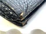 a black purse sitting on top of a white table