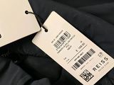 a label on a black jacket that says the label is on the tag