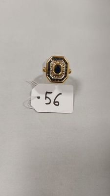 gros plan d'une bague sur une surface blanche avec une étiquette de prix