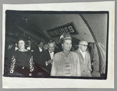 photographie en noir et blanc d'un groupe de personnes debout devant un bâtiment