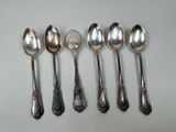 six spoons are lined up in a row on a table