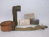 quelques objets posés sur une surface blanche, notamment une ceinture et un briquet