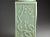 a green vase with a design on it on a table