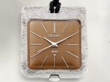 une horloge carrée argentée et marron suspendue à un cordon noir