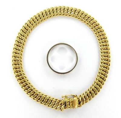 un gros plan sur un bracelet à chaîne en or orné d'une bague