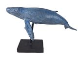 une statue de baleine bleue posée sur un socle noir, sur fond blanc