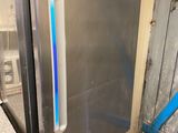 un réfrigérateur en acier inoxydable avec une lumière bleue sur la porte