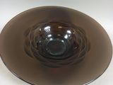 a glass bowl on a plate on a white table