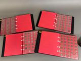 four red folders with coins on them sitting on a table
