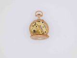 a close up of a gold pocket watch on a white surface