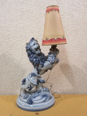 a blue and white statue of a rooster with a lamp on a table