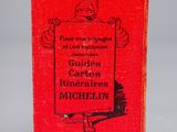 a red book sitting on top of a table next to a white table