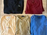 a group of men ' s polo shirts sitting on top of a wooden table