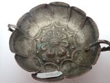 a silver bowl that has a flower design on it