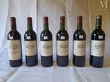 six bottles of wine are lined up in a row on a table