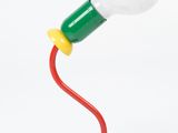 a red table lamp with a white light bulb on top of it
