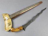 pair of antique wooden and metal knifes on a gray surface