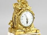 une horloge en or surmontée d'un ange