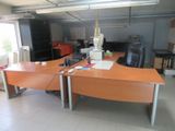 un bureau équipé d'un bureau, de chaises et d'un réfrigérateur