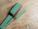 un sèche-cheveux vert posé sur une table en bois