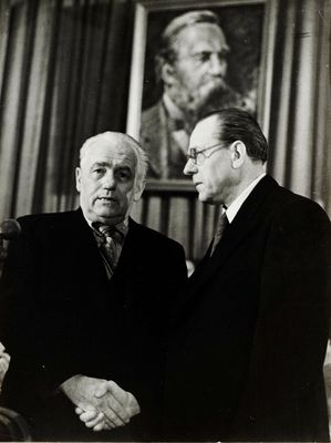 photographie en noir et blanc de deux hommes debout l'un à côté de l'autre