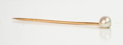 épingle à cheveux en perle et or sur fond blanc avec reflets