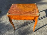 a small wooden table with a floral design on top of it