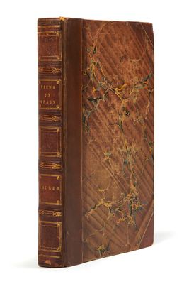 un vieux livre à la couverture brune posé sur une surface blanche