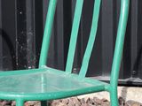 a green chair sitting in front of a black wall