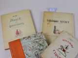 Trois livres sont posés sur une surface blanche ; l'un est orange et l'autre est vert.