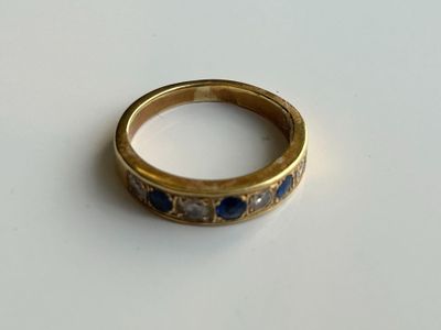 Gros plan sur une bague en or ornée de pierres bleues