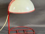 une lampe posée sur un pied, sur un fond gris