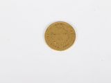 a close up of a gold coin on a white surface