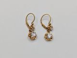 a pair of gold and diamond earrings on a white background