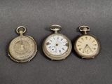 trois types différents de montres de poche posées sur une table