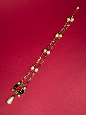 a close up of a necklace on a red surface