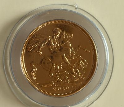 une pièce d'or dans un bol en verre transparent posé sur une table