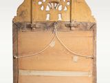an old wooden mirror hanging on a wall