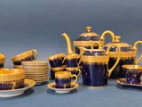 a blue and gold tea set with cups and saucers