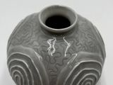 a gray vase sitting on a table with a white background