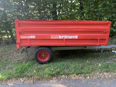 an image of a red dump truck parked in the grass