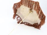 a white umbrella with brown fringes and a wooden handle
