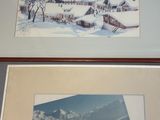 two framed pictures of snow covered mountains and a church in the distance