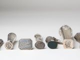 several different types of metal stampers are lined up on a white surface