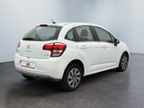 the rear end of a white citrole parked in a room