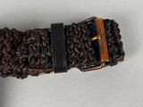 a brown belt with a wooden buckle on a white surface