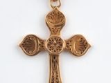 un pendentif en forme de croix en or orné d'un motif floral