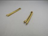 a pair of gold hair clips on a white surface